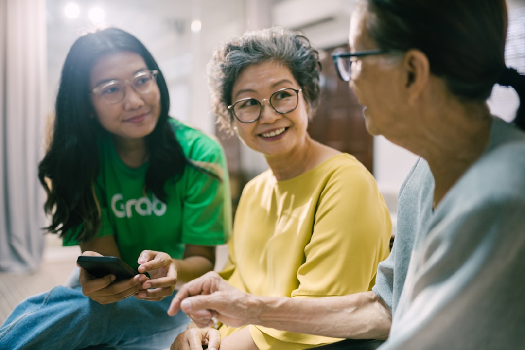 healthcare network — a group of women sitting on the floor looking at a cell phone